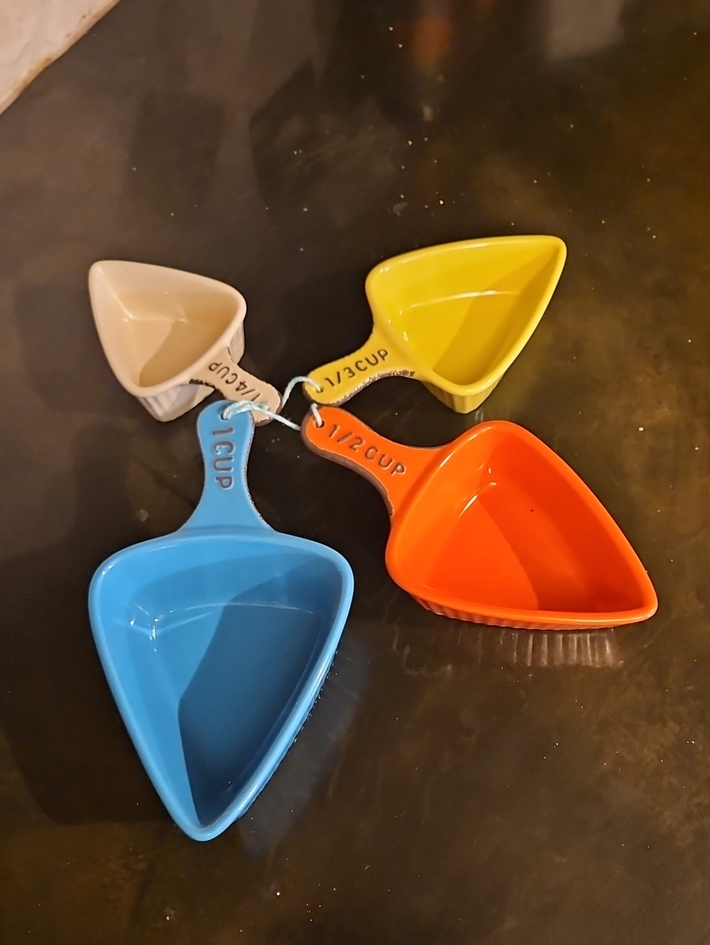 Creative Co-Op Ceramic Triangle Measuring Cups in Blue, Orange, Yellow, Cream